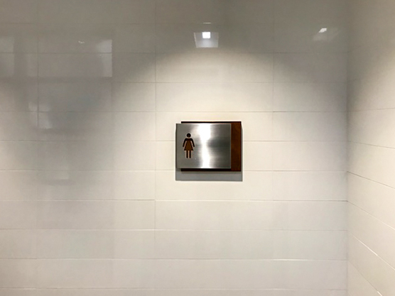 a commercial bathroom sign is hung on a wall