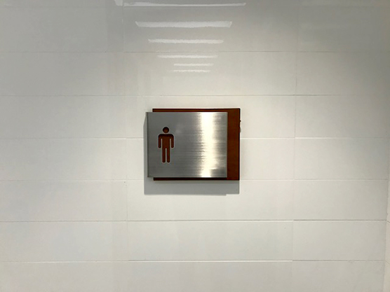 a mens washroom sign is hung on a wall